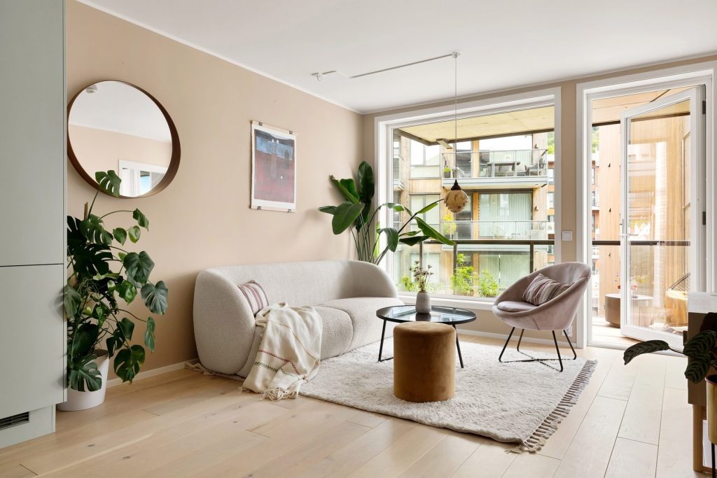Salon avec parquet clair et grande baie vitrée